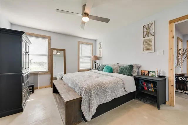 a bedroom with a bed and a dresser next to a window