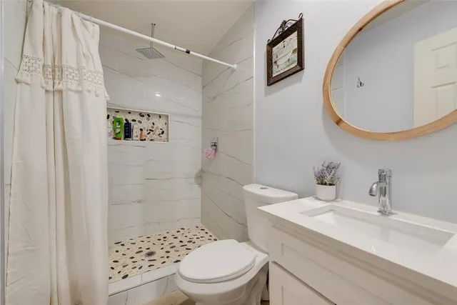 a bathroom with a sink a toilet and a mirror