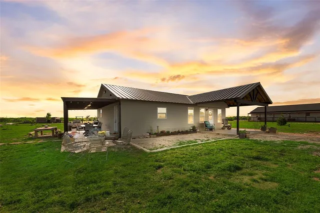 a backyard of a house with table and chairs