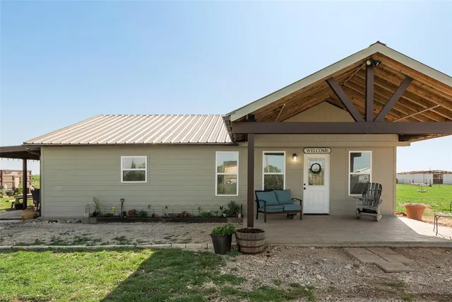a backyard of a house with yard and outdoor seating
