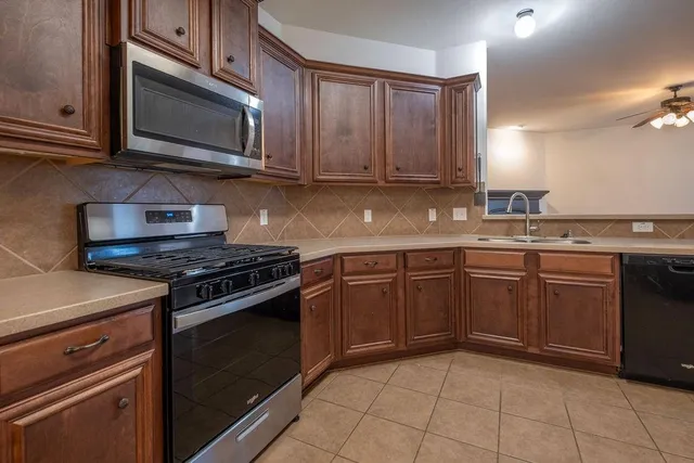 a kitchen with stainless steel appliances granite countertop a stove top oven microwave and cabinets