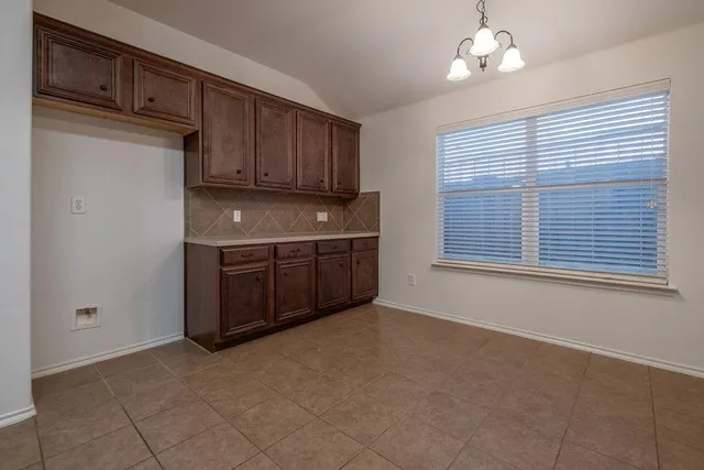 a view of a kitchen with cabinet a ceiling fan and windows