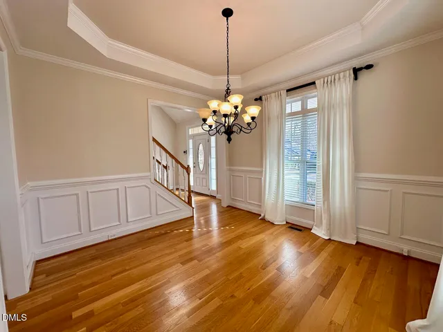 a view of a livingroom with wooden floor and a ceiling fan