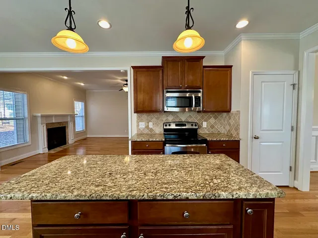 a kitchen with stainless steel appliances granite countertop a stove oven and a wooden cabinets