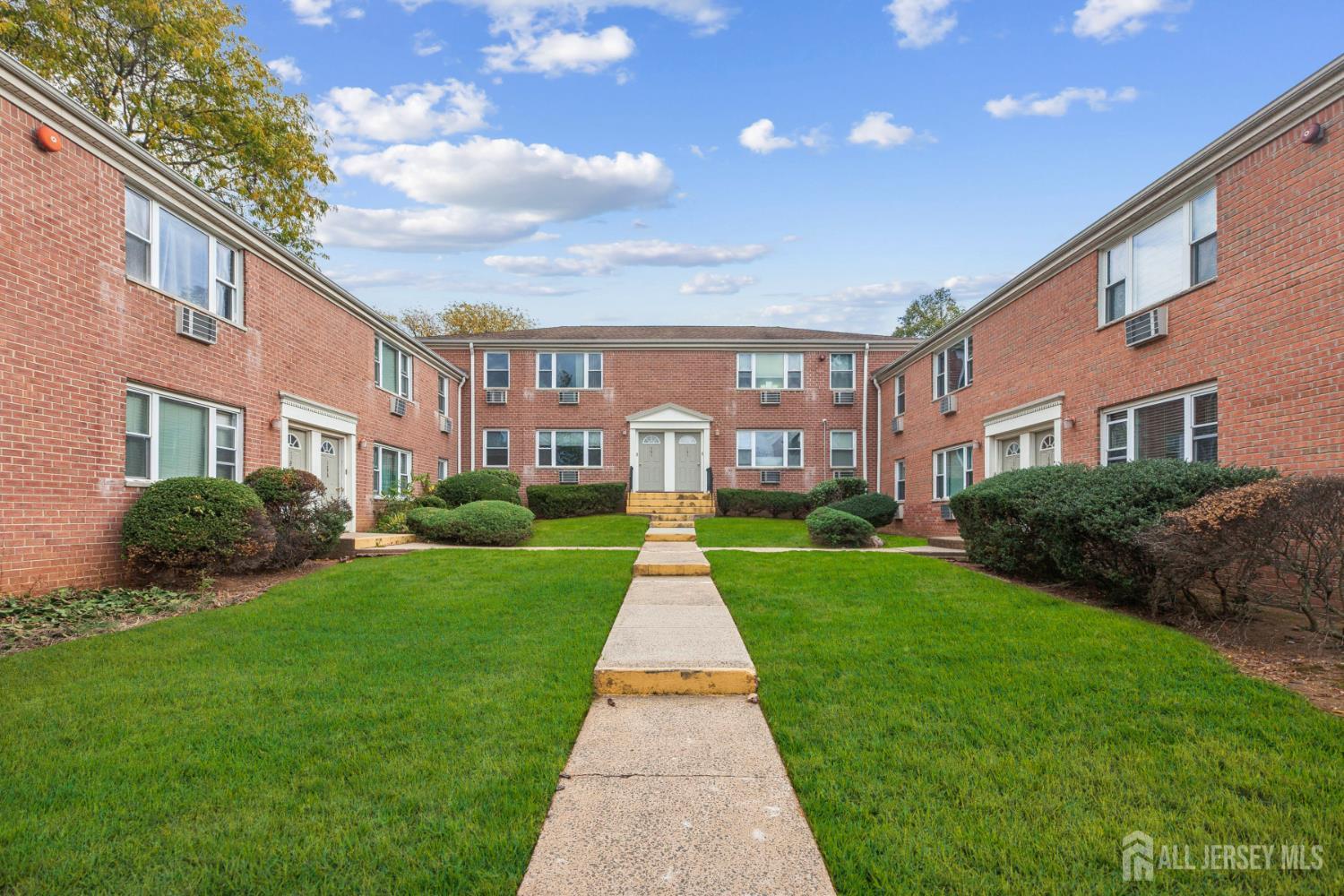 37 York Drive, Unit 6A Edison, NJ 08817 - Photo 15 of 20 a view of a brick house with a big yard and large trees