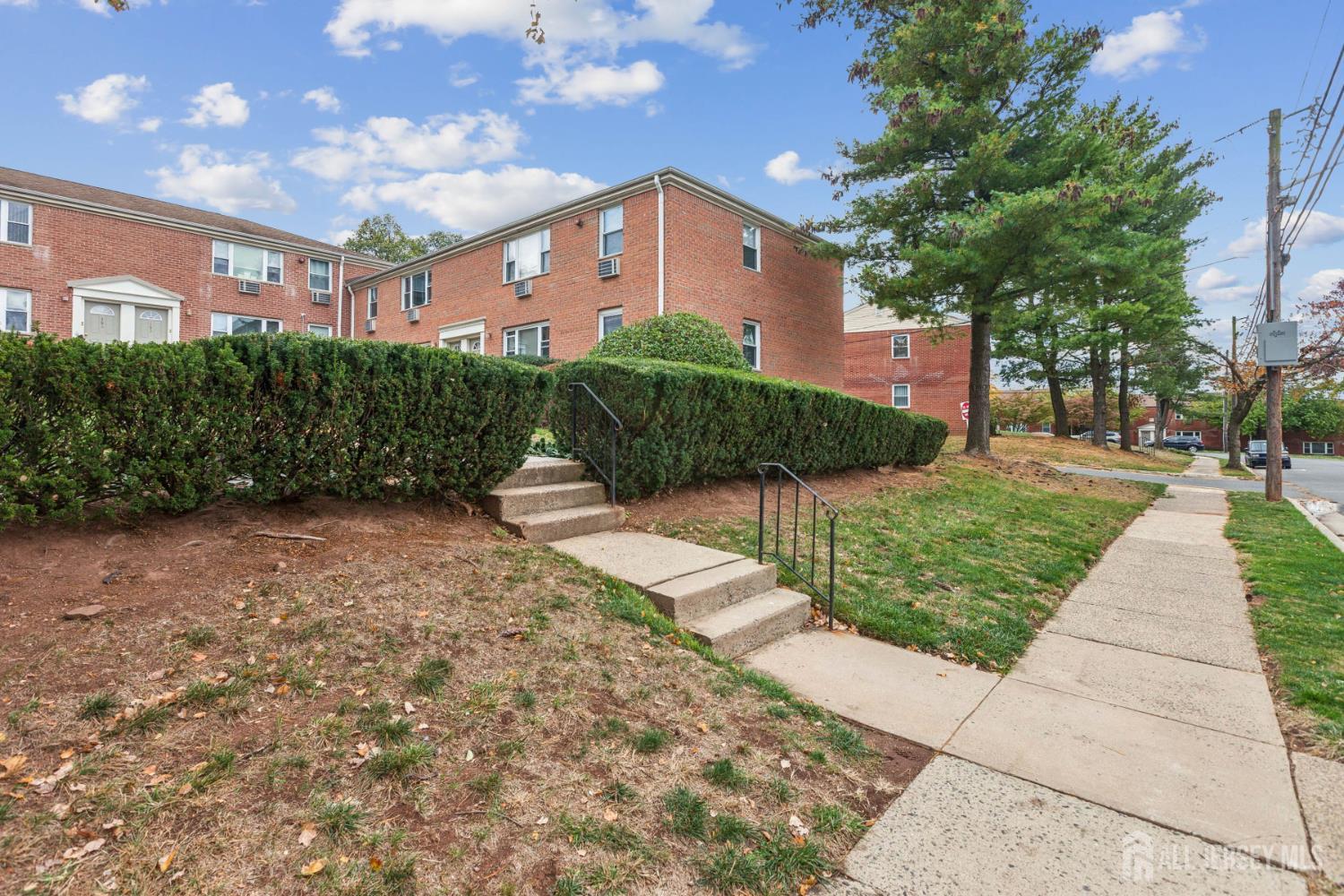 37 York Drive, Unit 6A Edison, NJ 08817 - Photo 17 of 20 a front view of a house with a yard and potted plants