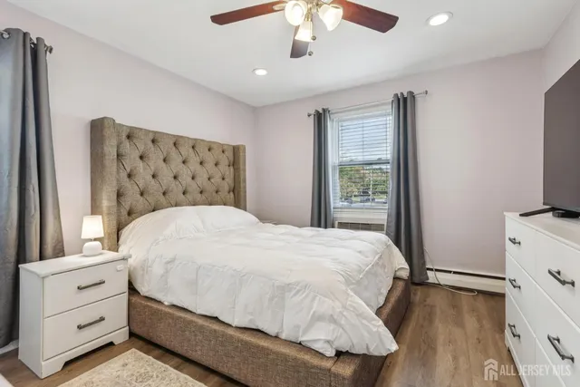 a bedroom with a bed and a flat tv screen on dresser