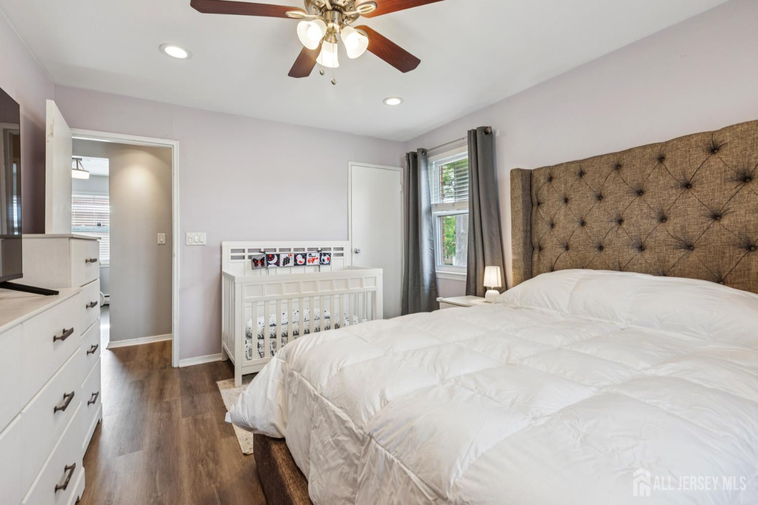 37 York Drive, Unit 6A Edison, NJ 08817 - Photo 9 of 20 a bedroom with a large bed and a chandelier