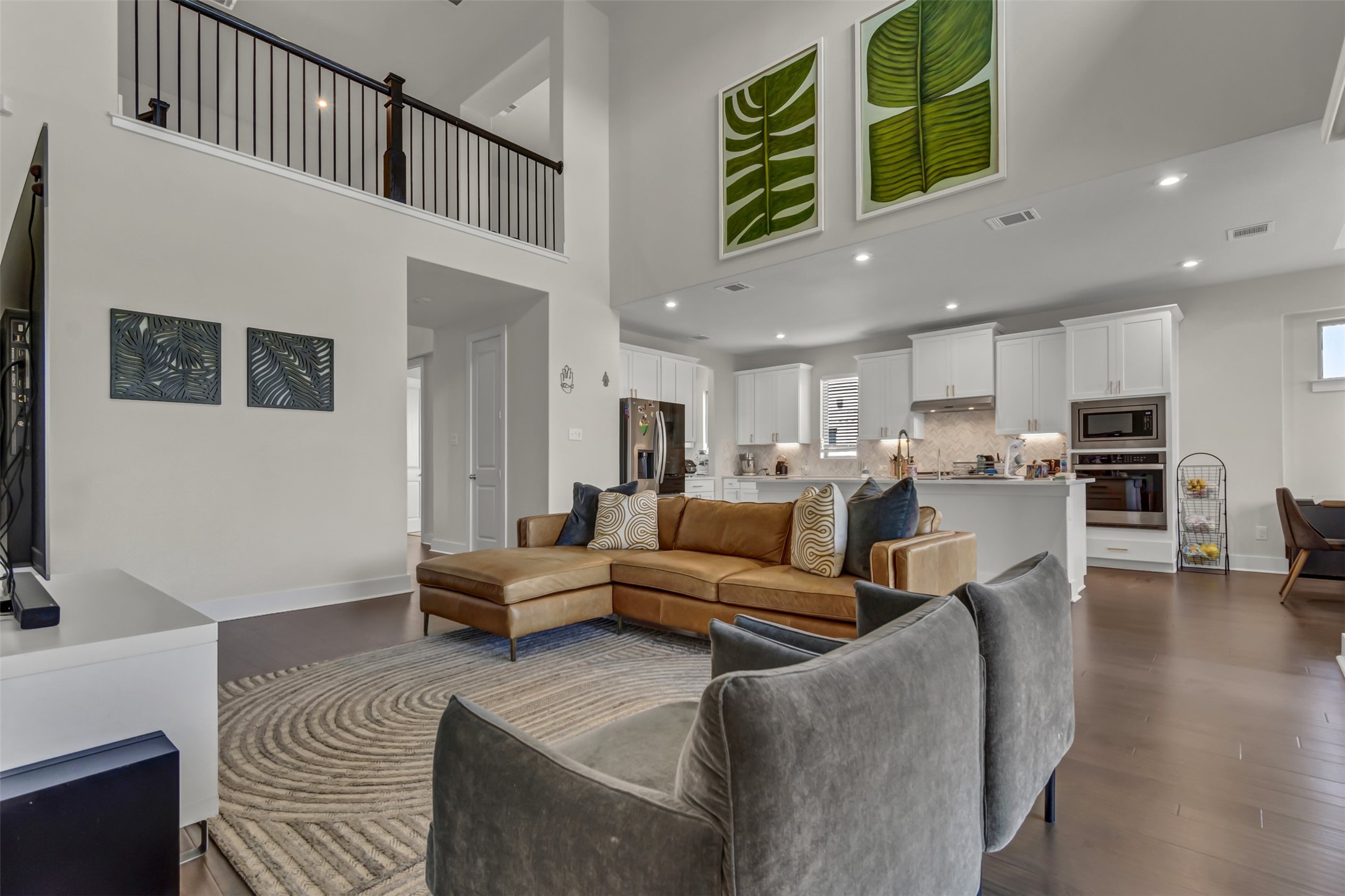 209 Azalea Spg Road Liberty Hill, TX 78642 - Photo 13 of 29 Open-concept living space featuring wood-finish flooring, a two-story ceiling, and recessed lighting