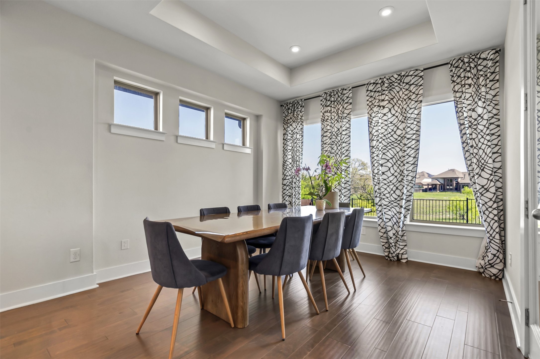 209 Azalea Spg Road Liberty Hill, TX 78642 - Photo 16 of 29 Spacious dining area featuring wood-finish flooring, a tray ceiling with recessed lighting, and multiple windows providing natural illumination