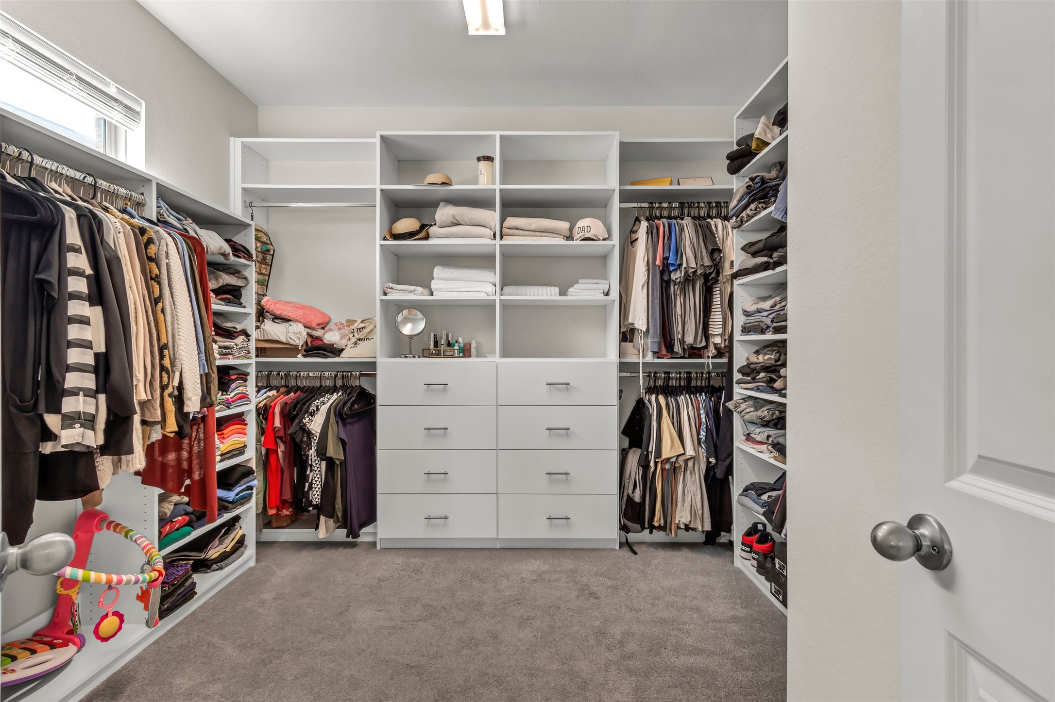 209 Azalea Spg Road Liberty Hill, TX 78642 - Photo 21 of 29 Spacious walk-in closet featuring custom white cabinetry with shelving and drawers, multiple hanging rods, and soft gray carpeting
