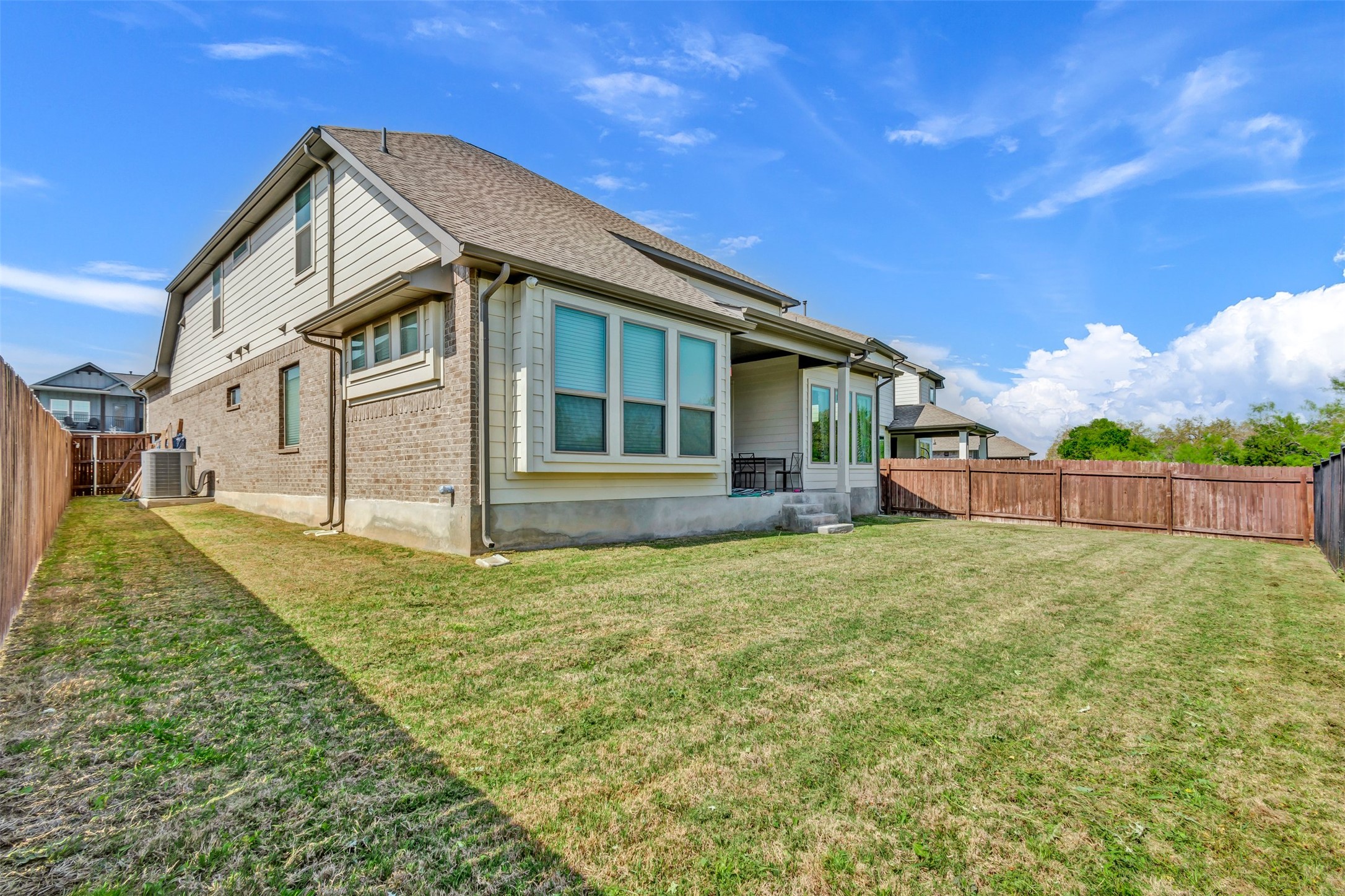 209 Azalea Spg Road Liberty Hill, TX 78642 - Photo 29 of 29 Expansive backyard with a manicured lawn, full privacy fencing, and a covered patio