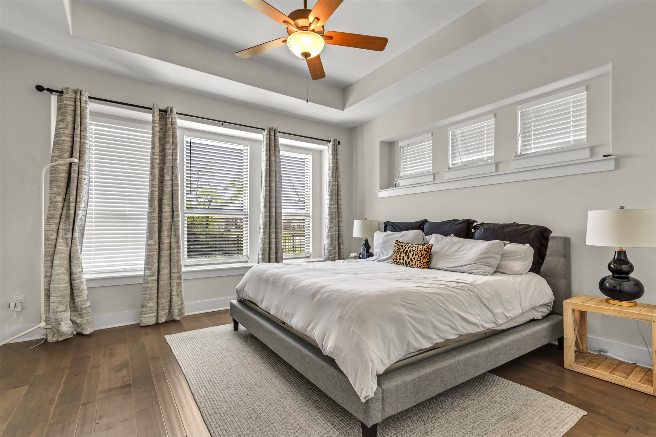 209 Azalea Spg Road Liberty Hill, TX 78642 - Photo 6 of 29 Spacious bedroom featuring warm wood-finish flooring, a tray ceiling, and a ceiling fan with integrated lighting