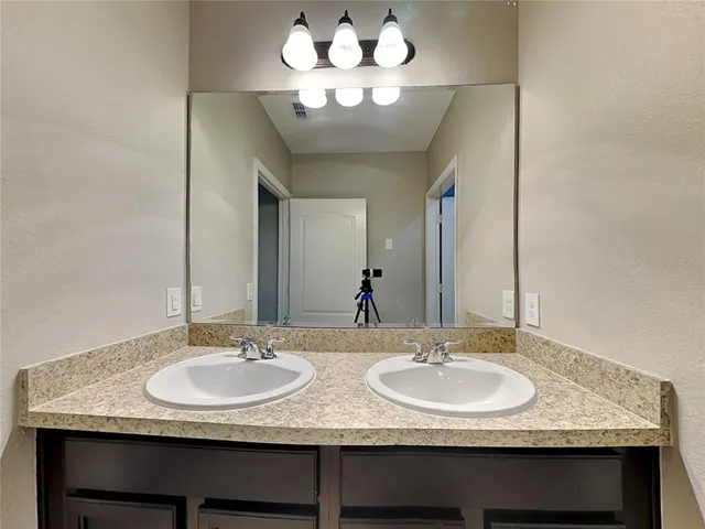 a bathroom with a granite countertop sink and a mirror