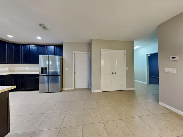 a kitchen with granite countertop a refrigerator and a stove top oven