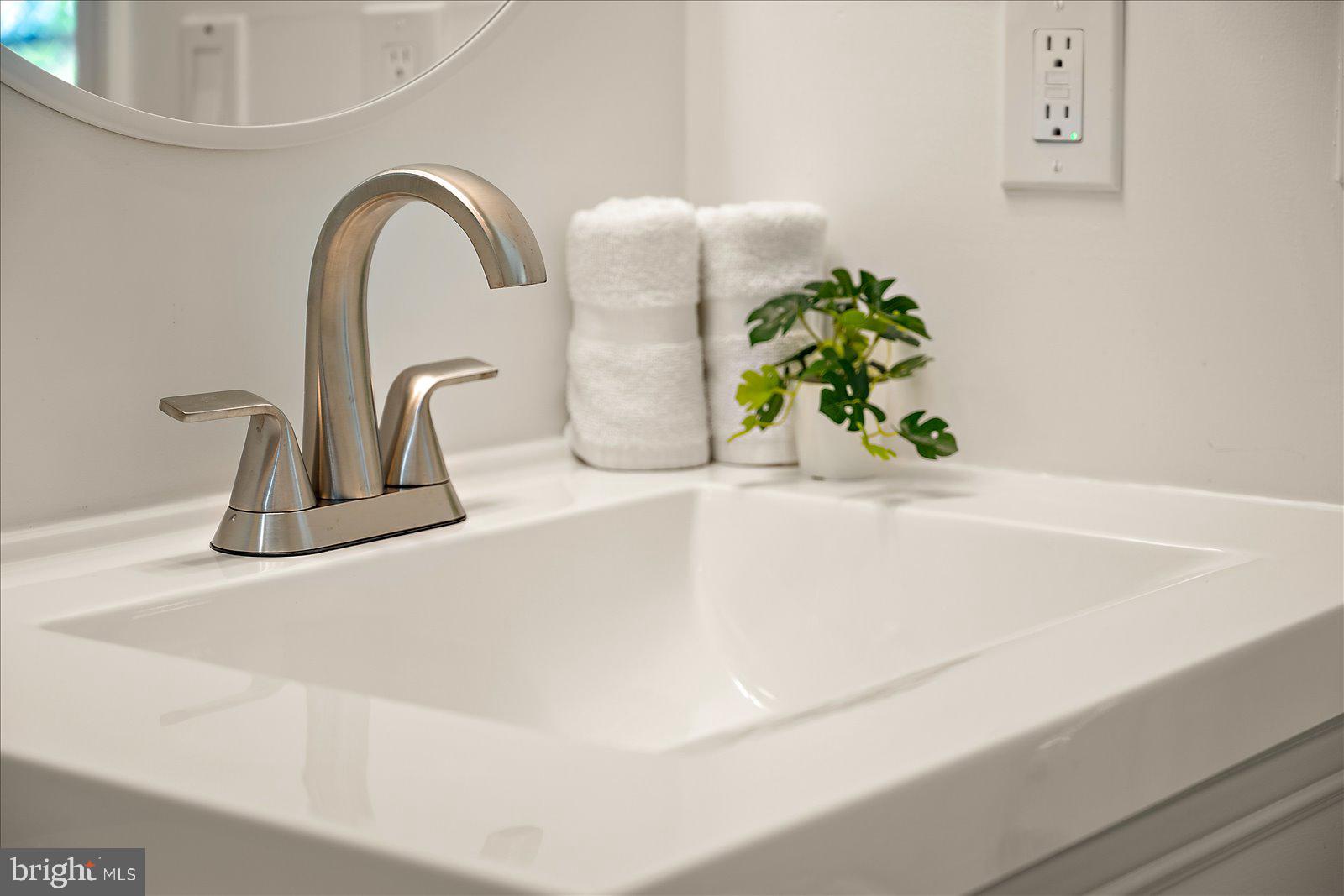 813 Shore Drive Edgewater, MD 21037 - Photo 28 of 64 a close view of a sink a faucet a faucet a mirror and a potted plant