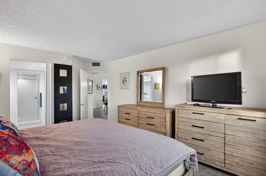 1801 Eleuthera Point, Unit D3 Coconut Creek, FL 33066 - Photo 26 of 80 a bedroom with a bed and a flat screen tv in white dresser