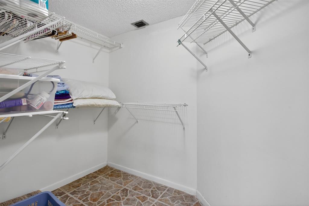 1801 Eleuthera Point, Unit D3 Coconut Creek, FL 33066 - Photo 31 of 80 a view of walk in closet with clothes and shoes