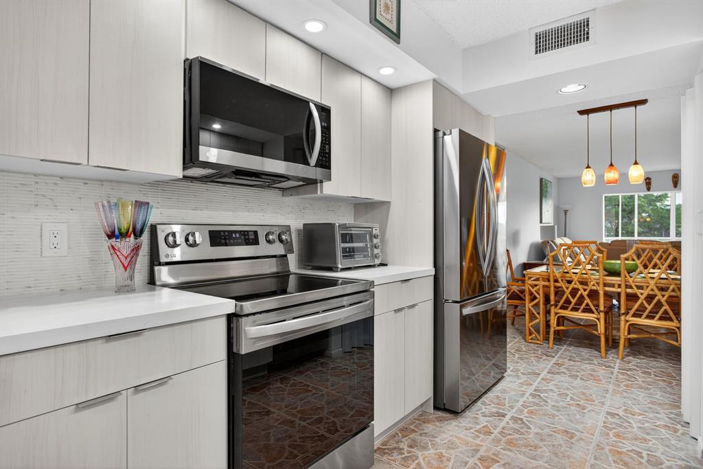 1801 Eleuthera Point, Unit D3 Coconut Creek, FL 33066 - Photo 7 of 80 a kitchen with stainless steel appliances a stove microwave and refrigerator