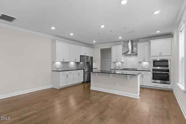 a large kitchen with granite countertop a large counter top stainless steel appliances and cabinets