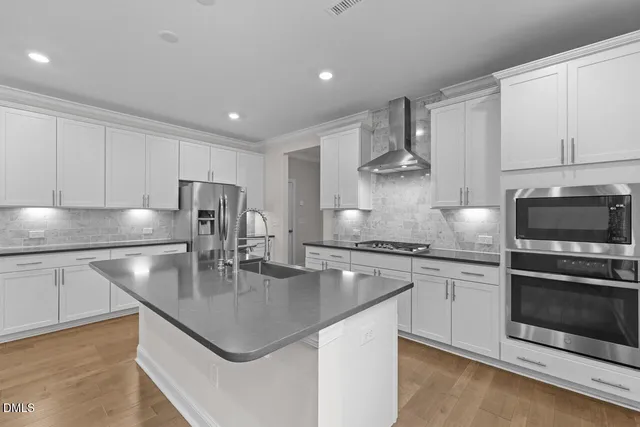 a kitchen with stainless steel appliances granite countertop a sink a stove and a refrigerator