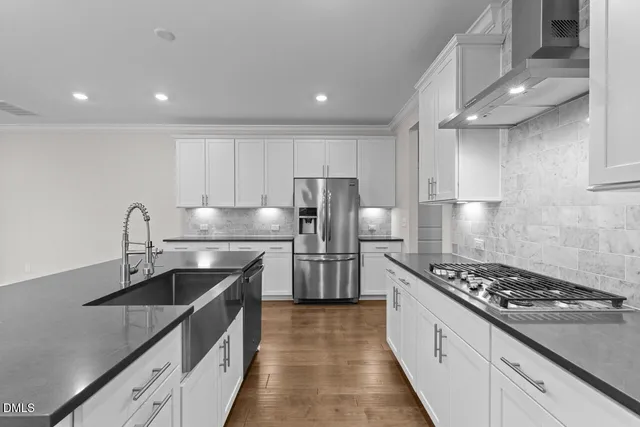 a kitchen with kitchen island stainless steel appliances a sink stove and refrigerator