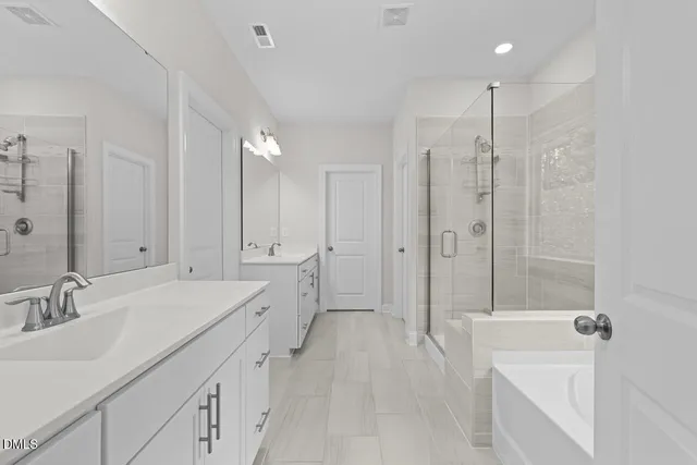 a spacious bathroom with a tub sink shower and mirror