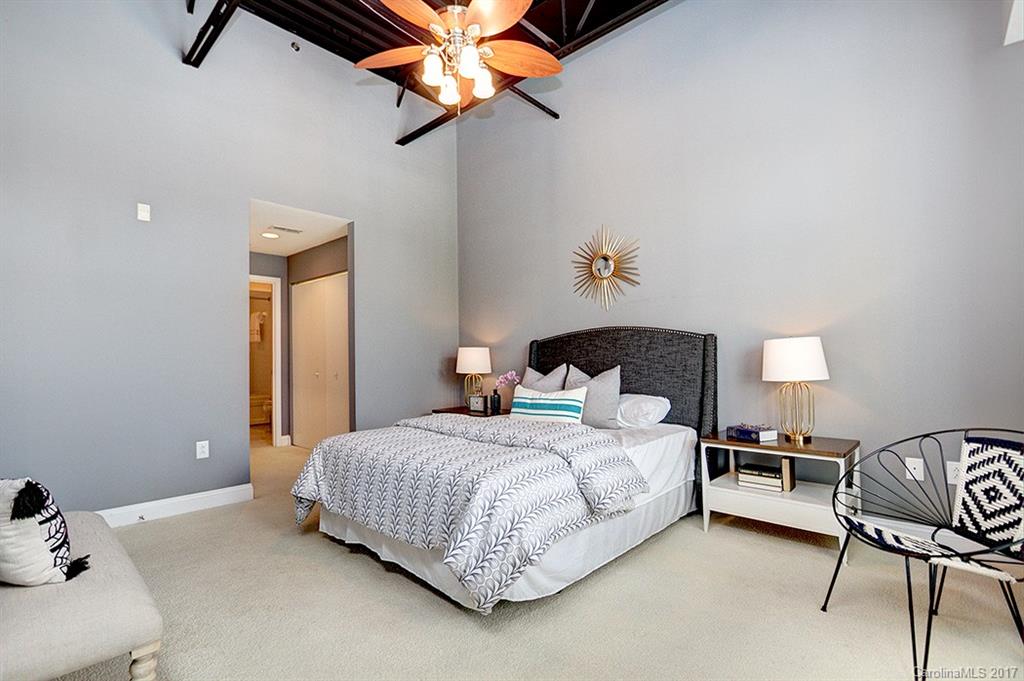3920 Sharon Road, Unit 206 Charlotte, NC 28211 - Photo 15 of 24 a bedroom with a bed and a chandelier