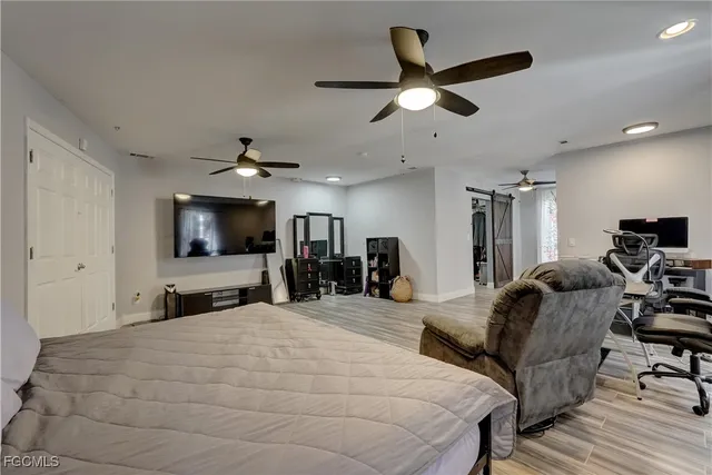 a large bedroom with a bed and a flat screen tv