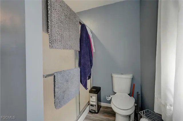 a white toilet sitting next to a shower curtain