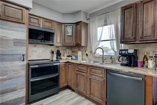 a kitchen with stainless steel appliances granite countertop a sink stove and microwave