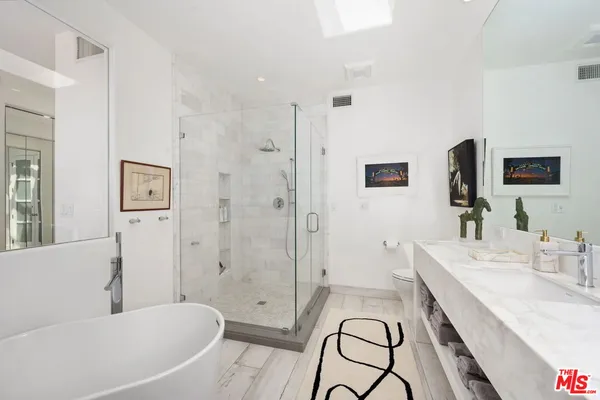 a spacious bathroom with a granite countertop tub sink a mirror a shower and a bath tub