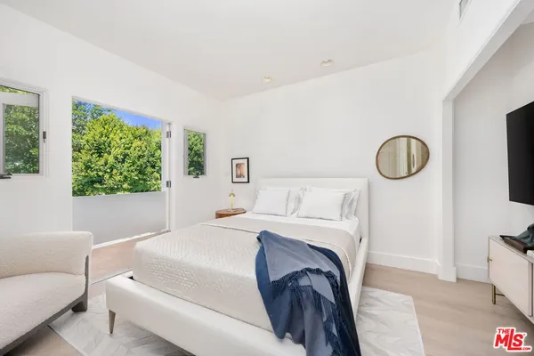 a bedroom with a bed and a large window