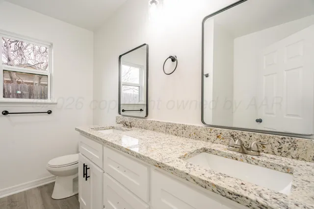 a bathroom with a granite countertop sink and a mirror