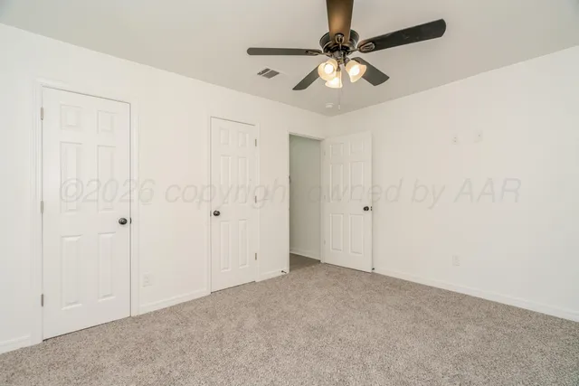 an empty room with a ceiling fan and a window