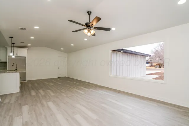 a view of a livingroom with a ceiling fan and window