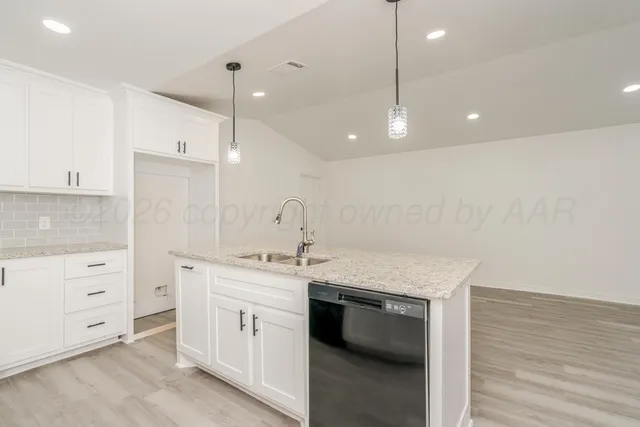 a kitchen that has a sink a stove and cabinets