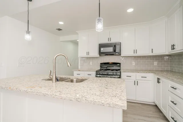 a kitchen with stainless steel appliances granite countertop a sink a stove and a granite counter tops