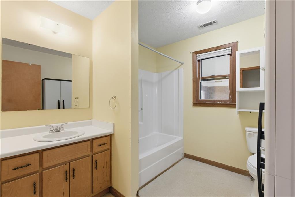 143 Copperhead Road Cornelia, GA 30531 - Photo 20 of 56 a bathroom with a granite countertop sink a mirror and a bathtub