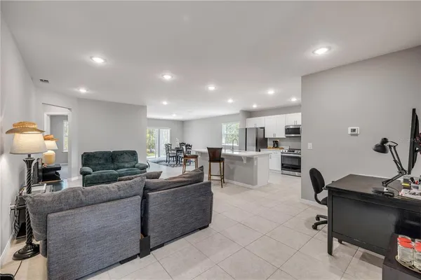 a living room with furniture and kitchen view