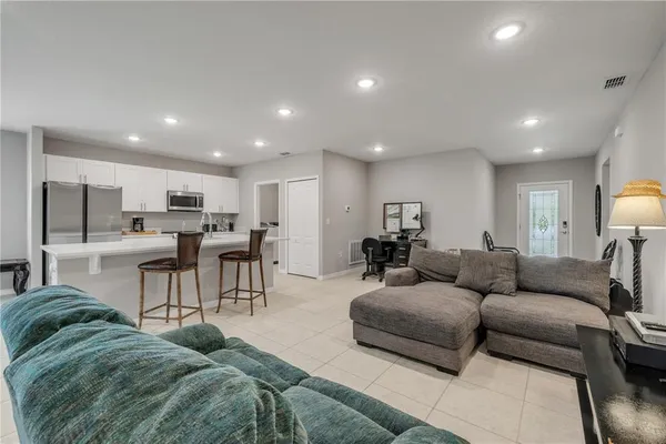 a kitchen with stainless steel appliances a dining table chairs stove refrigerator and sink