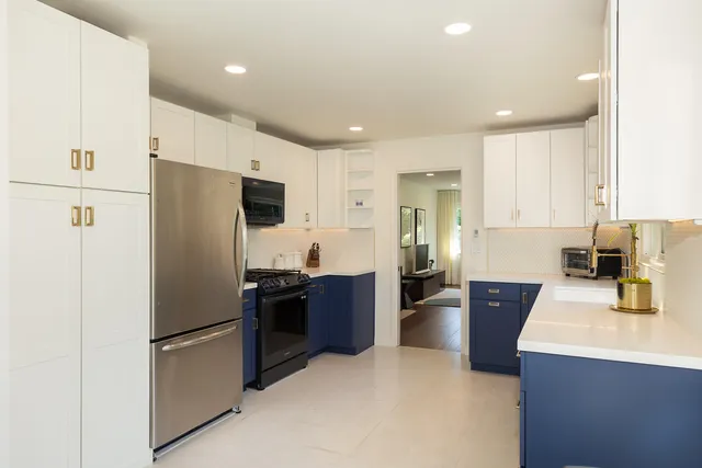 a kitchen with stainless steel appliances granite countertop a refrigerator and a stove