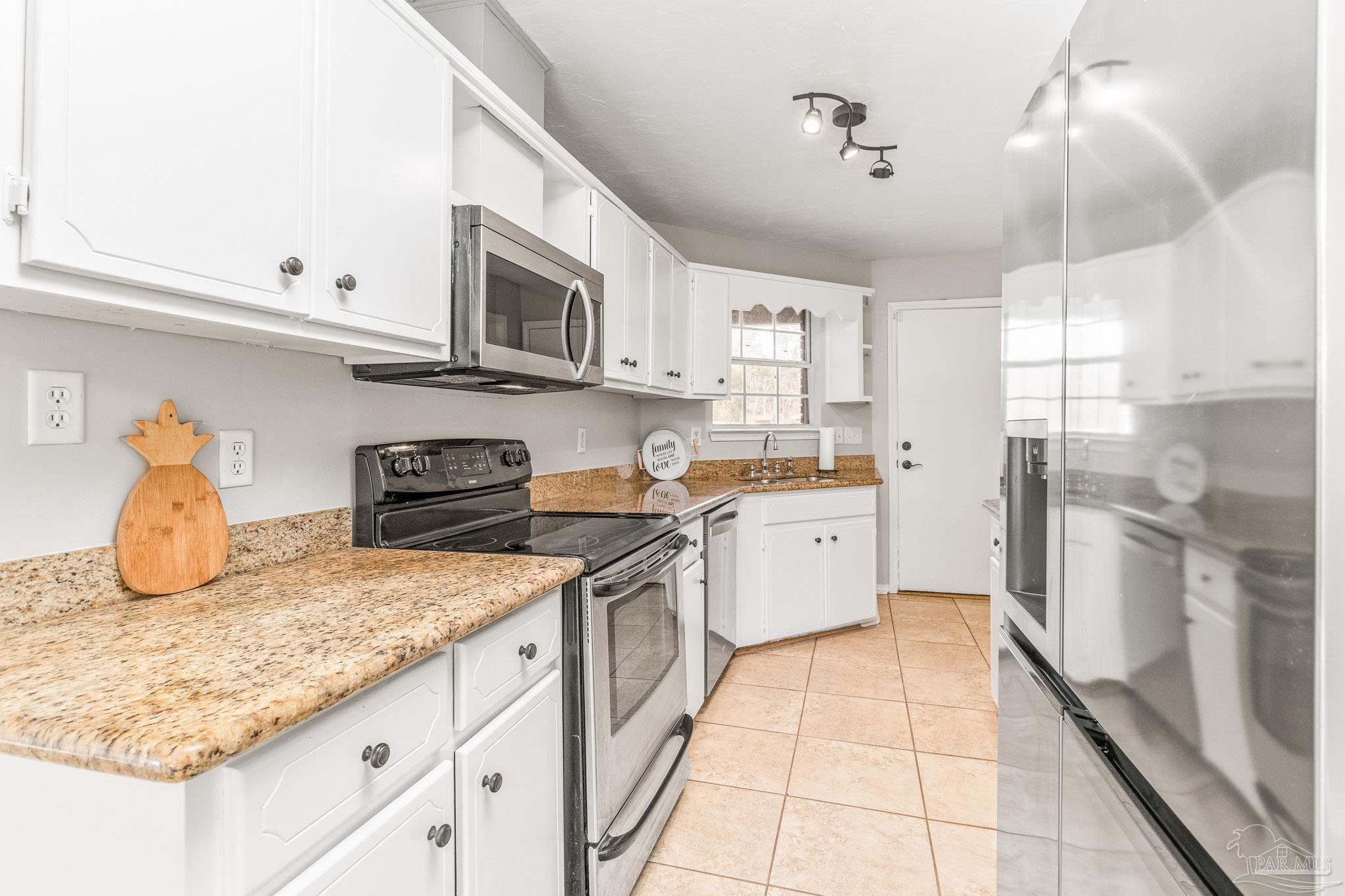 1655 Eagle Terrace Cantonment, FL 32533 - Photo 26 of 47 a kitchen with a sink a stove and cabinets