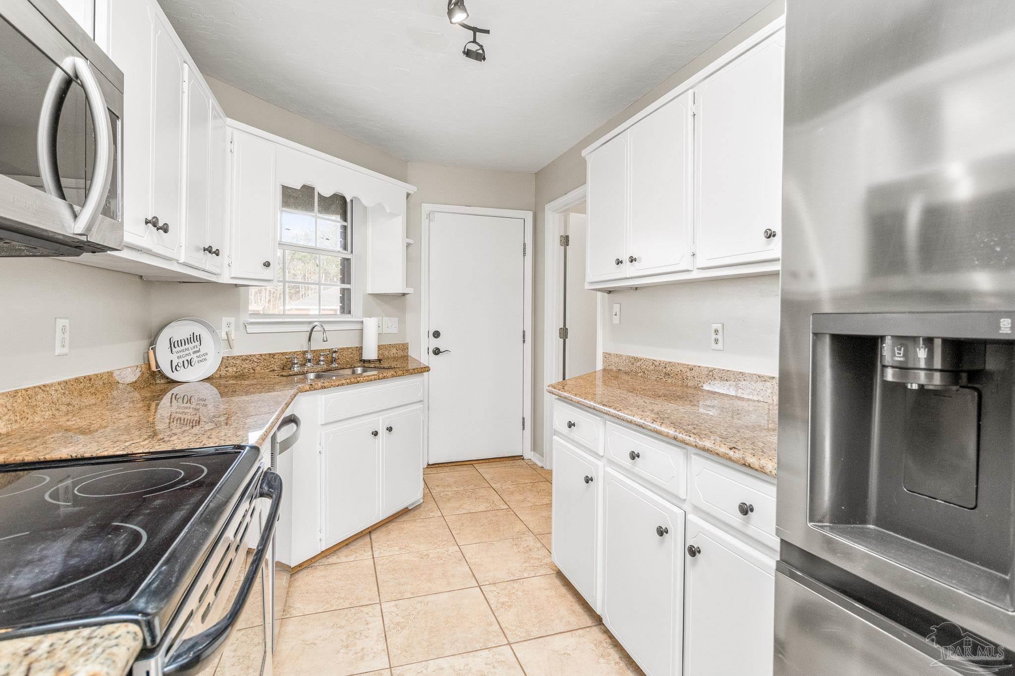1655 Eagle Terrace Cantonment, FL 32533 - Photo 27 of 47 a kitchen with granite countertop white cabinets and white appliances