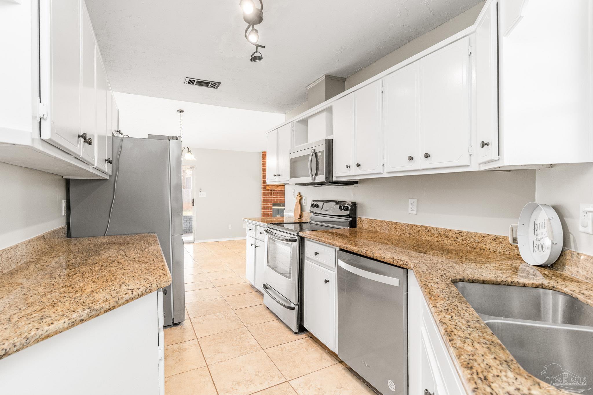 1655 Eagle Terrace Cantonment, FL 32533 - Photo 30 of 47 a kitchen with stainless steel appliances granite countertop a sink stove and refrigerator
