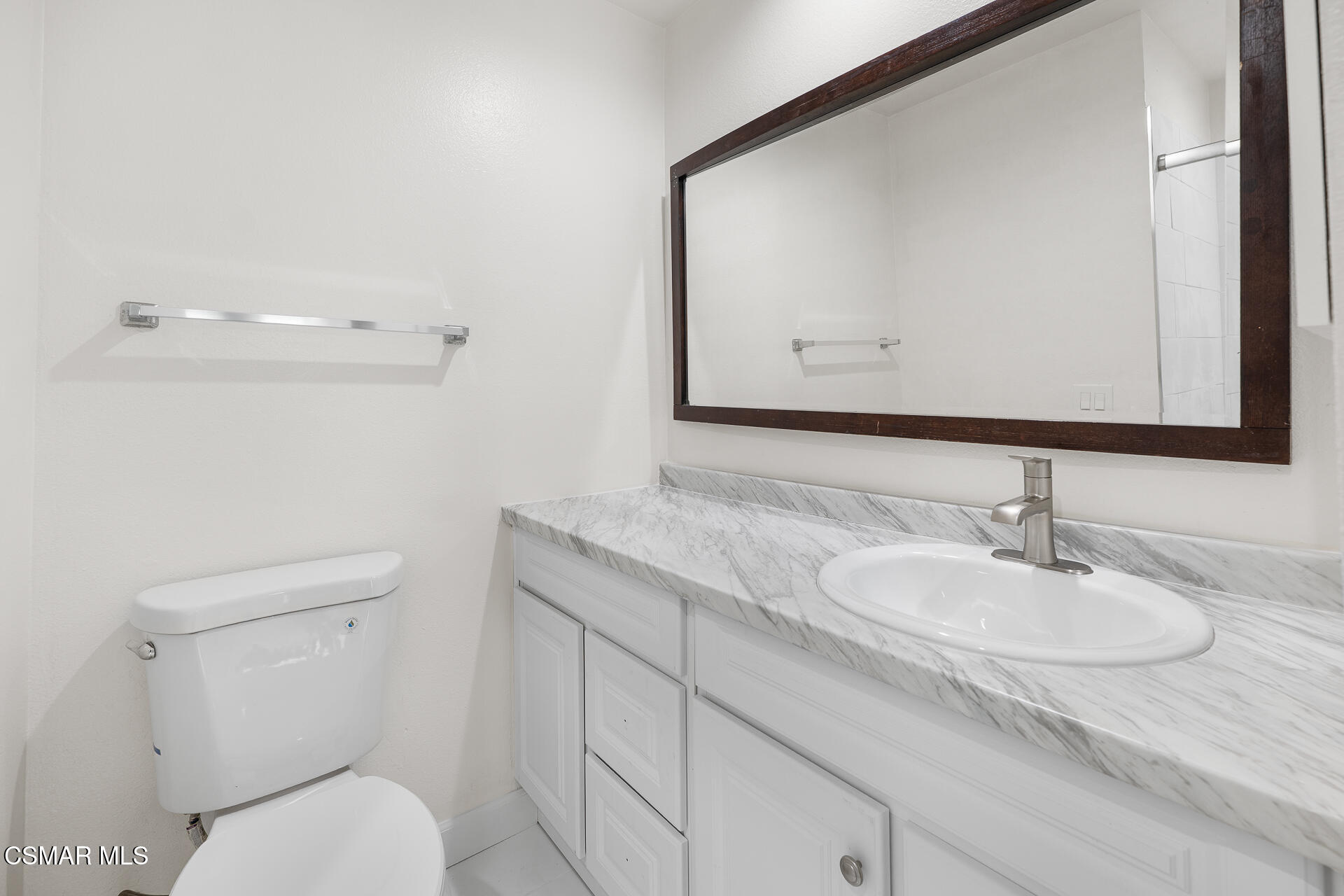 577 Spring Road, Unit 54 Moorpark, CA 93021 - Photo 16 of 23 a bathroom with a granite countertop toilet sink and mirror