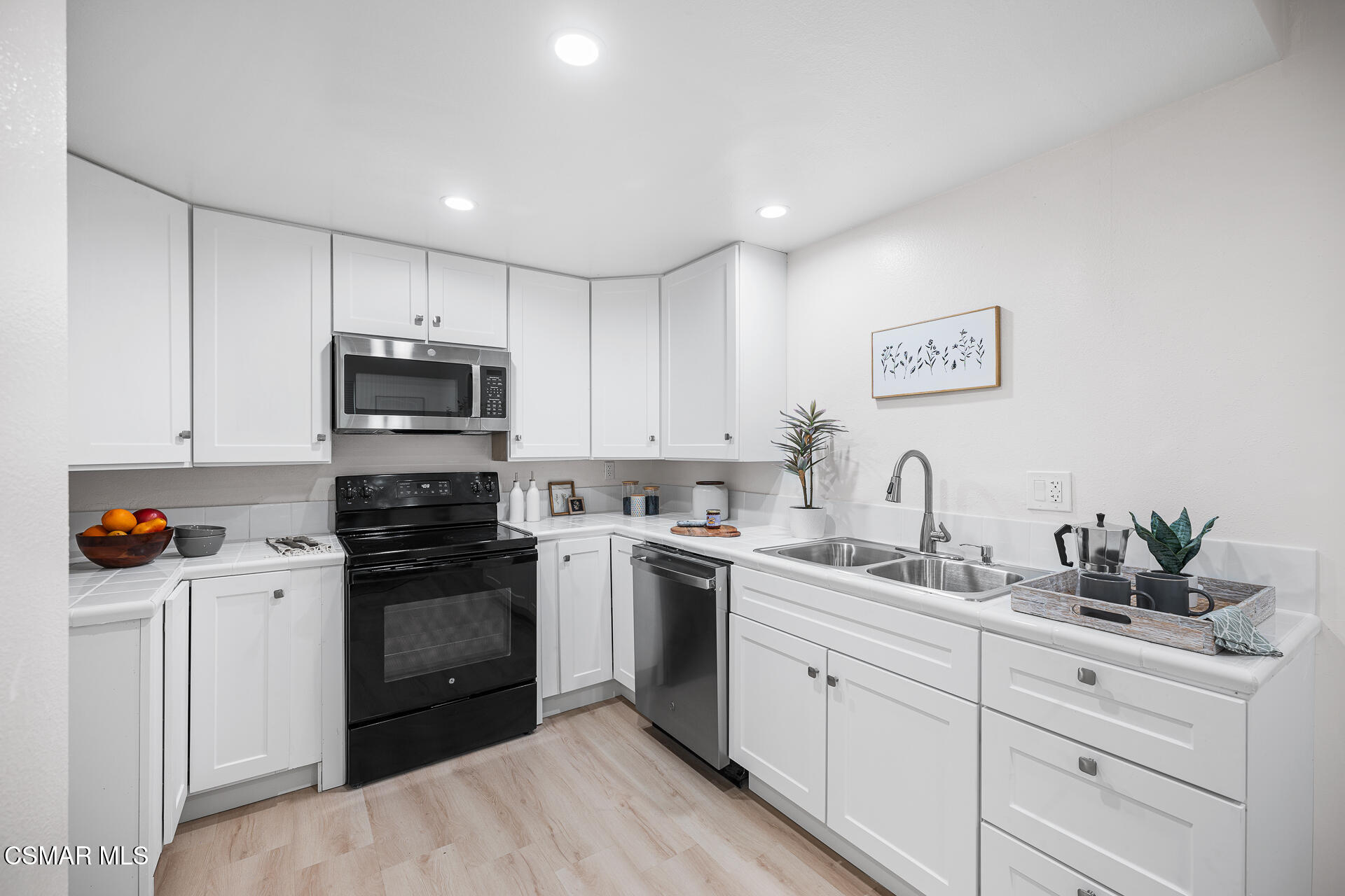 577 Spring Road, Unit 54 Moorpark, CA 93021 - Photo 6 of 23 a kitchen with a sink white cabinets and stainless steel appliances