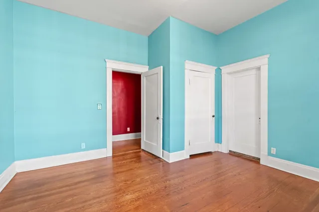 a view of an empty room with wooden floor