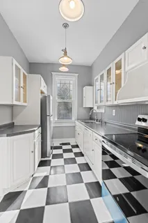 a kitchen with stainless steel appliances granite countertop white cabinets and window