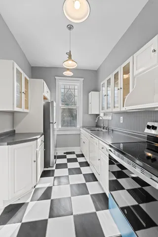 a kitchen with stainless steel appliances granite countertop white cabinets and window